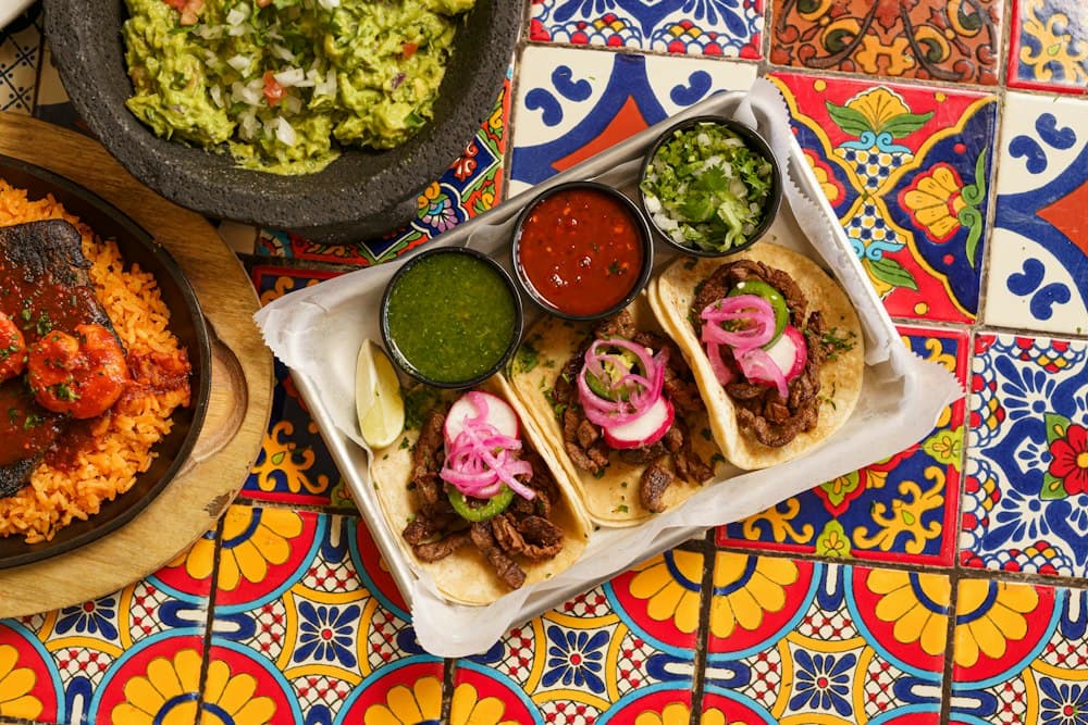 Guacamole in a molcajete with Mexican sides — demo imagery