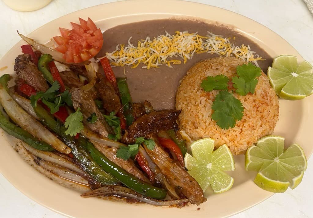 Steak fajitas with peppers, onions, rice, and beans from Melendez Imports