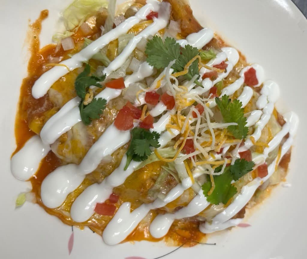 Wet tamales with sauce, cheese, and crema from Melendez Imports